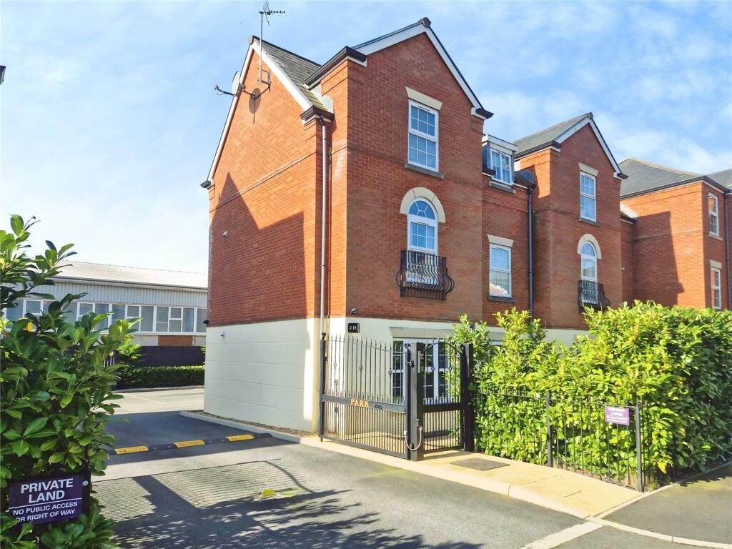 The gated entrance and apartment buildings at Kings Park in Leigh